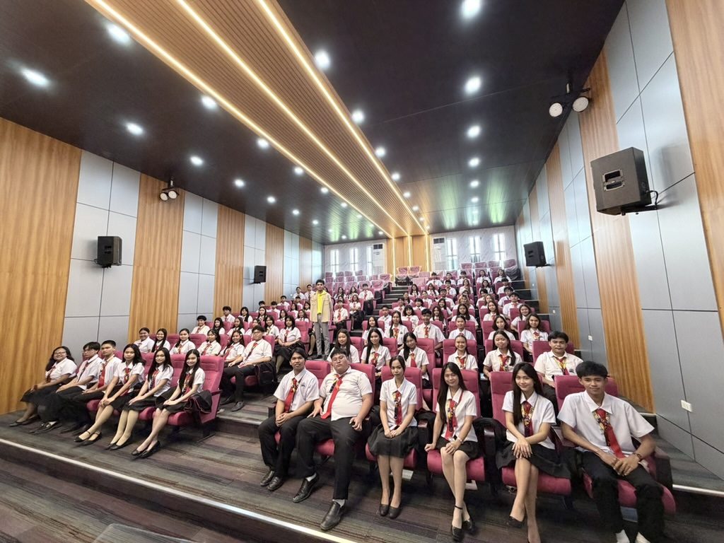 Wide view of Arcinas Hall showing black professional speaker cabinets mounted high on the oak-panelled side walls.