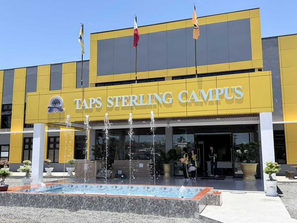 The TAPS Sterling Campus signed entrance with a fountain running in front of it.